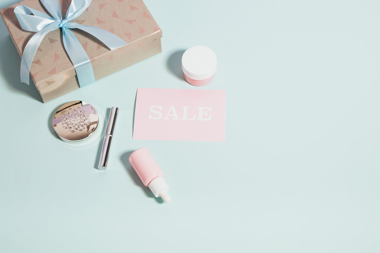 Stylish arrangement of beauty products with a sale card on a pastel background, perfect for promotional use.